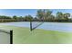 View of a community tennis court with green and blue surface, as seen through the surrounding fence at 12343 Halfmoon Lake Ter, Bradenton, FL 34211