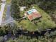 Aerial view of community center, pool, parking, and waterway with kayak access, surrounded by lush trees at 1239 Pinebrook Way, Venice, FL 34285
