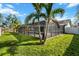 The backyard features a screened-in pool area and mature palm trees at 1239 Pinebrook Way, Venice, FL 34285