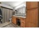 Bathroom featuring wood cabinets, granite counters, vanity with decorative mirror, and shower with curtain at 1239 Pinebrook Way, Venice, FL 34285