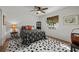 Bright bedroom featuring a ceiling fan, wooden floors, and stylish black and white patterned accents at 1239 Pinebrook Way, Venice, FL 34285