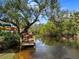 Scenic wooden dock on a serene waterway surrounded by lush greenery, ideal for relaxation and enjoying waterfront views at 1239 Pinebrook Way, Venice, FL 34285