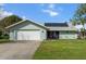 Charming single-story home with a two-car garage, solar panels, and a well-maintained front yard at 1239 Pinebrook Way, Venice, FL 34285