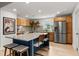 Modern kitchen boasts stainless steel appliances, wooden cabinetry, a large island, and stylish decor at 1239 Pinebrook Way, Venice, FL 34285