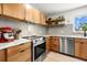 Bright kitchen with stainless steel appliances, wood cabinets, floating shelves, and lots of counter space at 1239 Pinebrook Way, Venice, FL 34285