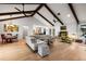 Inviting living area with vaulted ceilings, exposed wood beams, and a seamless transition to the kitchen at 1239 Pinebrook Way, Venice, FL 34285