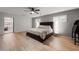 Spacious main bedroom with a ceiling fan, wood floors, shuttered windows, and neutral gray paint at 1239 Pinebrook Way, Venice, FL 34285