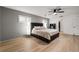 Large bedroom with modern lighting, wood floors, ceiling fan, and windows with white shutters at 1239 Pinebrook Way, Venice, FL 34285