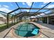 Sparkling in-ground pool inside screened enclosure, with patio area and lush landscaping at 1239 Pinebrook Way, Venice, FL 34285