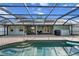 Outdoor pool and patio area with screened-in enclosure, with comfortable seating and outdoor dining at 1239 Pinebrook Way, Venice, FL 34285