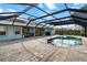 Enjoy the screened-in pool area with brick pavers and a summer kitchen at 1239 Pinebrook Way, Venice, FL 34285