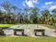 Outdoor shuffleboard courts surrounded by mature trees and lush landscaping for leisurely activities at 1239 Pinebrook Way, Venice, FL 34285