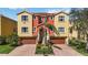 Mediterranean-style townhome with vibrant yellow and orange facade, tile roof, and two-car garage at 1308 3Rd Street E Cir, Palmetto, FL 34221