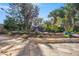 Paver patio and waterfall in the backyard surrounded by tropical landscaping and mature pine trees at 1565 Saturn Rd, Venice, FL 34293