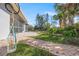 Screened in porch leading to a peaceful backyard featuring mature landscaping and a beautiful waterfall at 1565 Saturn Rd, Venice, FL 34293