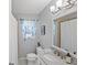 Neutral-toned bathroom featuring a marble countertop vanity, framed mirror, and shower with a curtain at 1565 Saturn Rd, Venice, FL 34293