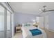 Cozy bedroom with a sliding glass door, ceiling fan, and nautical-themed decorations on the bedside tables at 1565 Saturn Rd, Venice, FL 34293