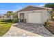 Charming single-story home featuring an attached garage, paver driveway, and a manicured front lawn at 1565 Saturn Rd, Venice, FL 34293
