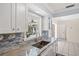 Updated kitchen features a modern sink, granite countertops, subway tile backsplash, and plenty of light at 1565 Saturn Rd, Venice, FL 34293