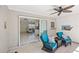 Covered lanai with ceiling fan and seating area adjacent to the kitchen and living room at 1565 Saturn Rd, Venice, FL 34293