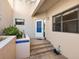 Warm and inviting entryway with tiled steps and a blue-tiled planter with lush plants at 1718 Starling Dr # 104, Sarasota, FL 34231