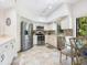 Modern kitchen with stainless steel appliances, tiled backsplash, white cabinets, and adjacent breakfast nook at 1718 Starling Dr # 104, Sarasota, FL 34231