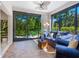 Bright sunroom with floor to ceiling windows, tile flooring and a comfortable blue sofa set at 1718 Starling Dr # 104, Sarasota, FL 34231