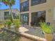 Back patio with sliding glass doors and outdoor furniture with a view of lush landscaping at 1718 Starling Dr # 104, Sarasota, FL 34231