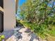 Paver patio featuring lush greenery with chairs and a small table overlooking a lake at 1718 Starling Dr # 104, Sarasota, FL 34231