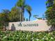 Community sign for The Landings, surrounded by flowers, shrubs and palm trees at 1718 Starling Dr # 104, Sarasota, FL 34231