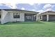 Well maintained backyard with lush green grass and a screened-in patio at 18821 Dayspring Pl, Venice, FL 34293