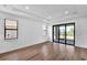 Bright bedroom featuring hardwood floors, multiple windows, and sliding glass doors at 18821 Dayspring Pl, Venice, FL 34293