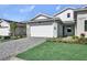 Charming home with a two-car garage, green lawn, and a beautifully paved driveway at 18821 Dayspring Pl, Venice, FL 34293