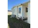 Exterior shot of the home with a window and the AC unit with green grass and a blue sky at 197 Palm Harbor Dr, North Port, FL 34287