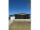 A bright home featuring a screened porch and utility shed, with a clear blue sky at 197 Palm Harbor Dr, North Port, FL 34287