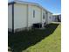 Side view of the home's exterior shows grass and the AC unit at 197 Palm Harbor Dr, North Port, FL 34287