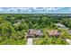 Aerial view showcasing the house, with solar panels, surrounded by green trees and neighboring homes at 2625 Yuma Ave, North Port, FL 34286