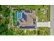 Beautiful aerial view of a home with solar panels and a screened pool, surrounded by lush greenery at 2625 Yuma Ave, North Port, FL 34286