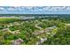 Picturesque aerial view of a neighborhood featuring homes with swimming pools, surrounded by lush greenery and sunny skies at 2625 Yuma Ave, North Port, FL 34286