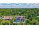 Aerial view of a home showcasing a screened pool, solar panels and lush landscaping, providing privacy and energy efficiency at 2625 Yuma Ave, North Port, FL 34286