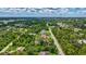 Expansive aerial view of a neighborhood with lush greenery, beautiful landscaping, and blue skies at 2625 Yuma Ave, North Port, FL 34286