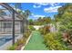 The manicured backyard features artificial turf and vibrant foliage, offering a serene outdoor retreat at 2625 Yuma Ave, North Port, FL 34286