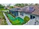Well-maintained backyard featuring a screened pool, solar panels, artificial turf and manicured landscaping at 2625 Yuma Ave, North Port, FL 34286