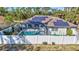 Enchanting backyard with a screened-in pool, solar panels, and a pristine white fence at 2625 Yuma Ave, North Port, FL 34286