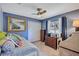 Cozy bedroom featuring bright blue walls, ceiling fan, and a comfortable daybed at 2625 Yuma Ave, North Port, FL 34286