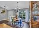 Dining area features a round table, modern lighting, hardwood floors, and a large window at 2625 Yuma Ave, North Port, FL 34286