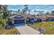 Inviting one-story home showcasing lush greenery, mature trees, and a freshly sealed driveway at 2625 Yuma Ave, North Port, FL 34286