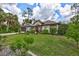 Charming home featuring verdant lawn, mature trees, and beautifully landscaped flowerbeds at 2625 Yuma Ave, North Port, FL 34286
