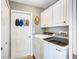 Efficient laundry room featuring white appliances, storage cabinets, and a practical layout at 2625 Yuma Ave, North Port, FL 34286