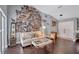 Comfortable living room featuring hardwood floors, a cream sofa, and a unique photo wall at 2625 Yuma Ave, North Port, FL 34286